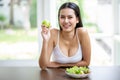 happy sexy young asian woman in white singlet smiling , holding green apple and eating fresh organic salad . A beautiful girl have Royalty Free Stock Photo