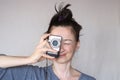 Happy shaggy middle aged casual woman taking photo with the camera social active and smiling on grey wall background