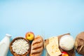 Happy Shavuot concept. Frame made of cereal bread, cottage cheese, bottle of milk, wheat, cheese on blue background. Jewish