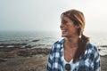 She is always happy when shes out in nature. a cheerful young woman standing on rocks next to the ocean while laughing Royalty Free Stock Photo