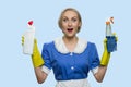 Happy shocked housekeeping woman presenting cleaning supplies.