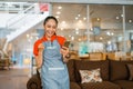 happy shop assistant woman using mobile phone in furniture store