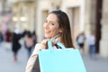 Happy shopper showing blank shopping bag