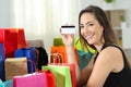 Happy shopper showing a credit card at home