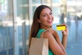 Happy shopping woman showing her credit card. Girl with shopper bag holding her credit card at the camera Royalty Free Stock Photo