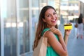 Happy shopping woman showing her credit card. Girl with shopper bag holding her credit card and show it at the camera. Royalty Free Stock Photo