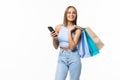 Happy shopping woman texting on her cell phone isolated over white Royalty Free Stock Photo