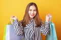 Happy shopping woman on yellow background