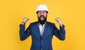 Happy shouting businessman in hard hat celebrating success, happiness