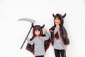 Happy sibling girls at the Halloween party. Children wearing costumes Halloweens. Concept of children ready for a party