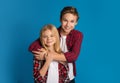 Happy siblings, brother and sister hugging and posing over blue background Royalty Free Stock Photo