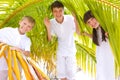 Happy siblings in palm fronds