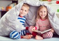 Happy siblings reading book under cover Royalty Free Stock Photo