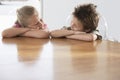 Happy Siblings Resting On Dining Table Royalty Free Stock Photo