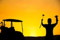 Happy silhouette male golfer winner holding tournament trophy in evening