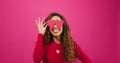 Happy silly woman poses with heart eyes, lovestruck infatuated emoji pink studio
