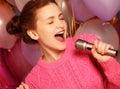 Happy singing girl. Beauty woman with microphone over backgroun Royalty Free Stock Photo