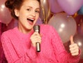 Happy singing girl. Beauty woman with microphone over backgroun Royalty Free Stock Photo