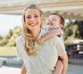 Happy single mother giving her little son a piggyback ride outside in a garden. Smiling caucasian single parent bonding Royalty Free Stock Photo