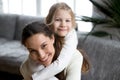 Happy single mother laughing piggybacking little girl daughter, Royalty Free Stock Photo