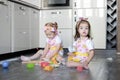 Happy sisters children girls bake cookies, knead dough, play with flour and laugh in the kitchen Royalty Free Stock Photo