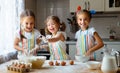 Happy sisters children girls bake cookies, knead dough, play wit Royalty Free Stock Photo