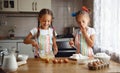 Happy sisters children girls bake cookies, knead dough, play wit Royalty Free Stock Photo