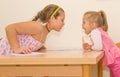 Happy sisters drawing in kitchen