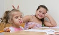 Happy sisters drawing in kitchen