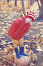 Happy boy sitting on pumpkin outdoors in autumn. Helloween. Royalty Free Stock Photo