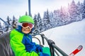 Happy ski boy sit on skier lift smile over forest Royalty Free Stock Photo
