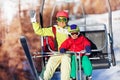 Happy skiers lifting on chairlift at mountains Royalty Free Stock Photo