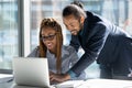 Happy skilled young male african leader helping colleague. Royalty Free Stock Photo