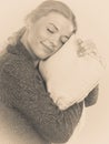 Happy sleepy woman holding and hugging pillow