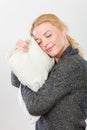 Happy sleepy woman holding and hugging pillow