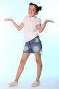 Happy slender child girl full growth in denim shorts with bare legs