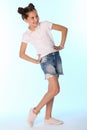 Happy slender child girl full growth in denim shorts with bare legs