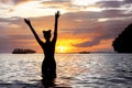 Happy slim girl raised arms sunset sea beach Royalty Free Stock Photo