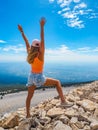 Happy slim girl is standing at sunset mountains with raised arms and enjoying the view from the top of Mont Ventoux Royalty Free Stock Photo