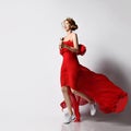 Happy slim sporty woman queen in golden crown, long red dress and white sneakers does exercises running with dumbbells Royalty Free Stock Photo