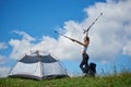 Woman tourist near camping in the mountains with backpack and trekking sticks in the morning Royalty Free Stock Photo