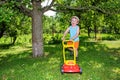 Happy small boy help with gardening with his lawn mower Royalty Free Stock Photo