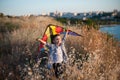 Happy small boy holding colorful kite over his head on the background of field and city with sea Royalty Free Stock Photo