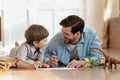 Emotional positive father involved in funny domestic activity with son.