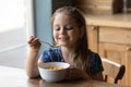 Happy small cute kid girl eating crunchy fast dry meal. Royalty Free Stock Photo