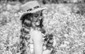 Happy small girl with beauty look wear sun hat on long curly blonde hair holding poppy flowers on natural sunny summer Royalty Free Stock Photo