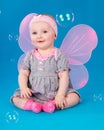 Happy small girl butterfly wings sitting on the floor Royalty Free Stock Photo