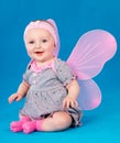 Happy small girl butterfly wings sitting on the floor Royalty Free Stock Photo