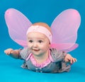 Happy small girl butterfly wings sitting on the floor Royalty Free Stock Photo