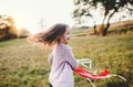 A small girl playing with a rainbow hand kite in autumn nature at sunset. Royalty Free Stock Photo